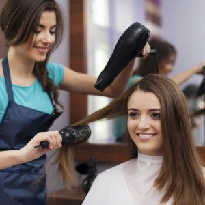 female-hairdresser-using-hairbrush-hair-dryer-scaled.jpg