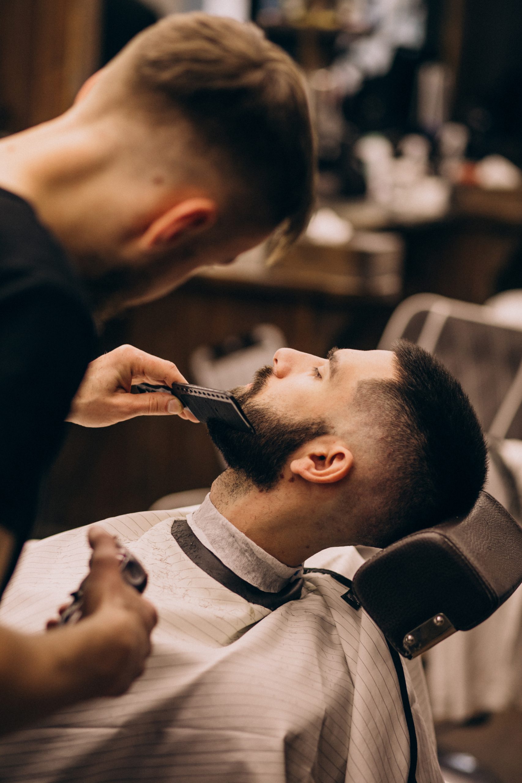 Man at a barbershop salon doing haircut and beard trim